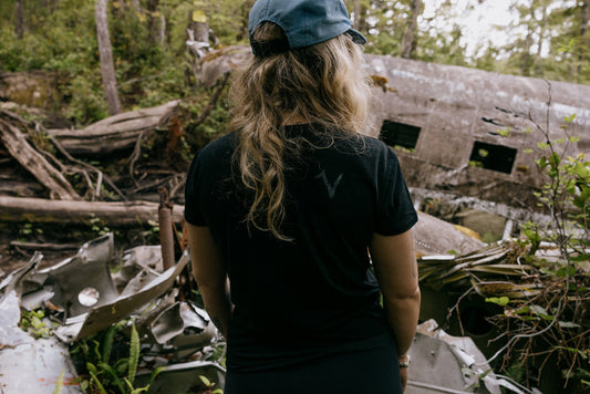 Woman wearing VOORMI Short Sleeve Tech Tee with plane crash in background